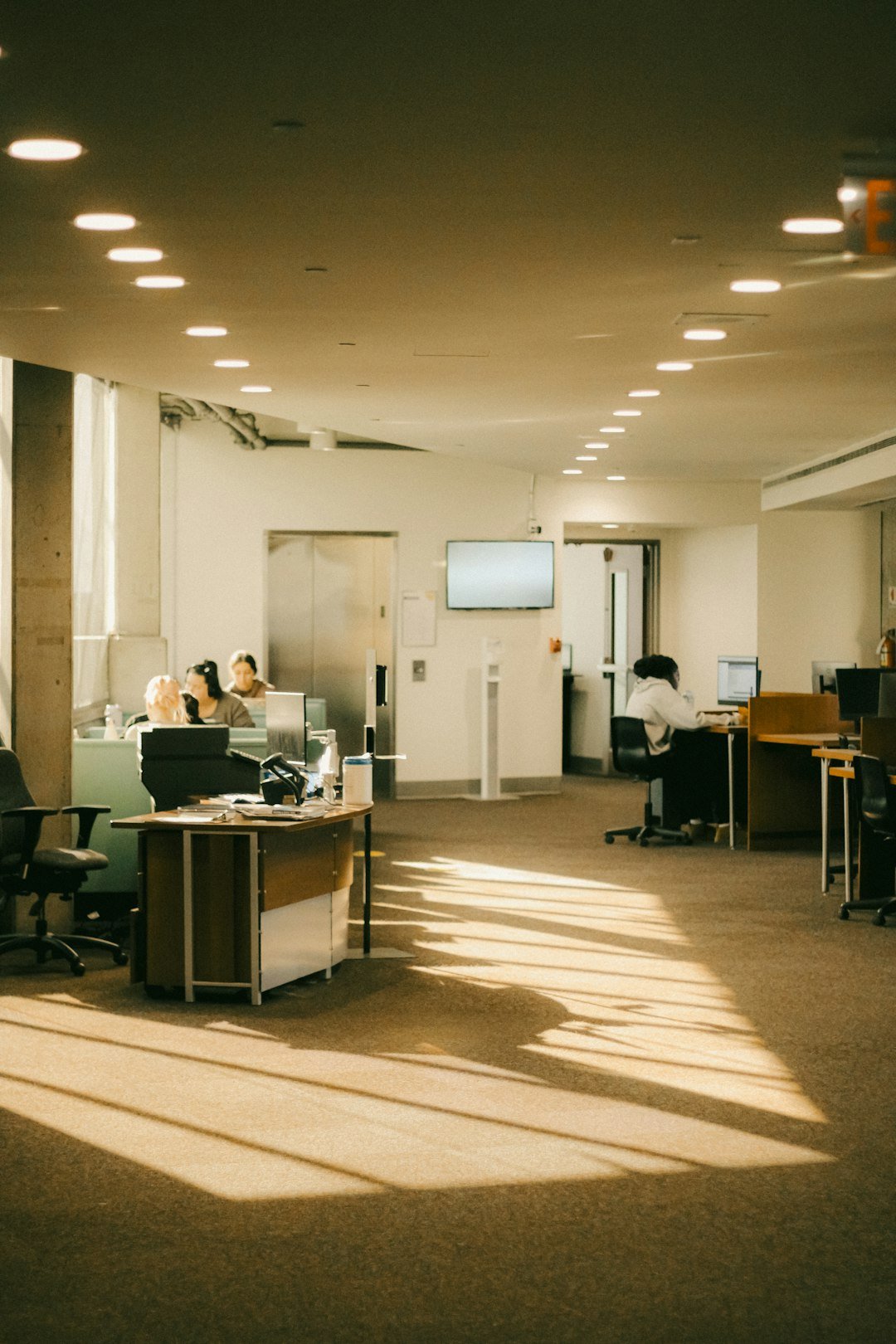 setting sunlight on the floor of a public library study area with students